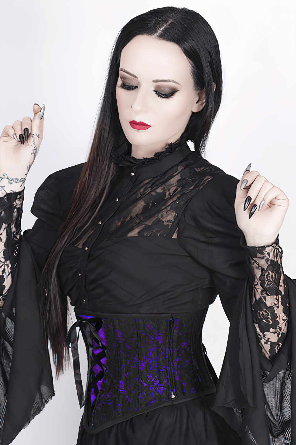 Gothic woman in black lace top wearing a purple lace overlay underbust corset, showcasing elegance and style.