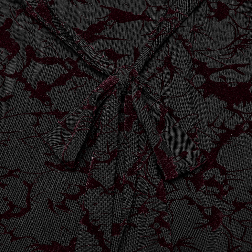 Close-up of Gothic black fabric with intricate burgundy patterns and a tie detail.