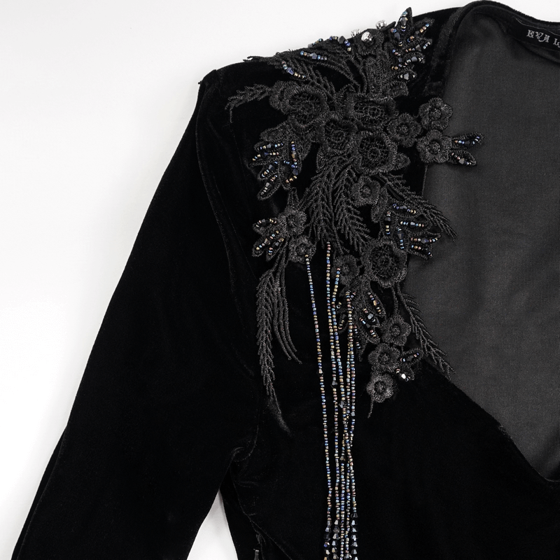 Close-up of elegant black velvet dress featuring intricate lace applique and beaded floral designs.