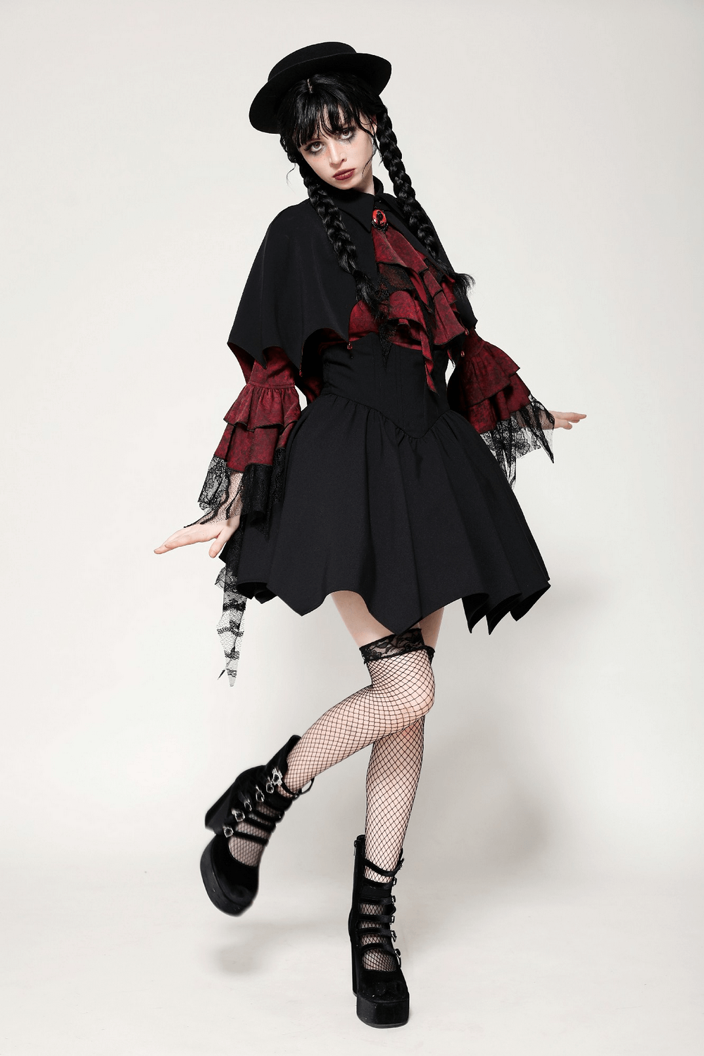 Model in Gothic vampire cape with high collar, red accents, and statement hat. Perfect for cosplay or Halloween.