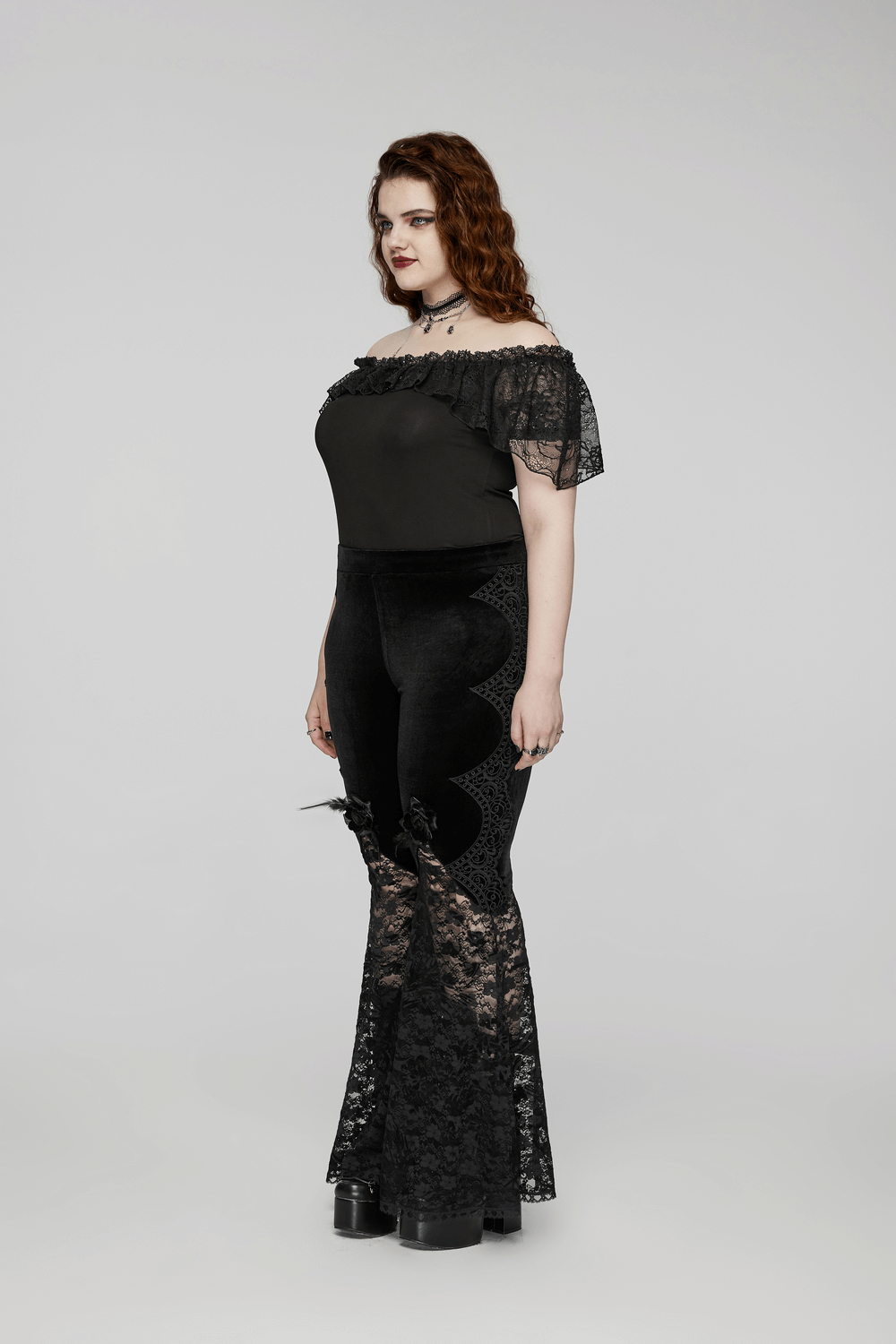 Gothic velvet and lace flared pants with rose trim on model, highlighting curves in elegant black lace design.