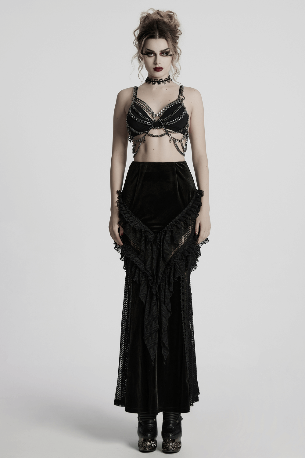 Gothic velvet and lace ruffle skirt with mesh detailing, paired with a stylish chain bra top, for a dramatic look.