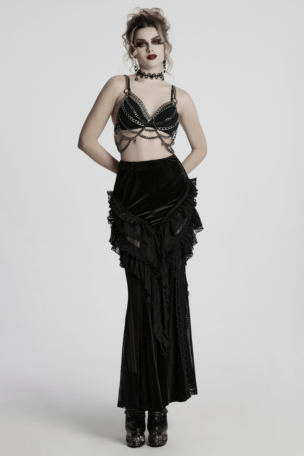 Gothic velvet and lace ruffle skirt with mesh detailing modeled with a stylish chain top, perfect for edgy fashion lovers.