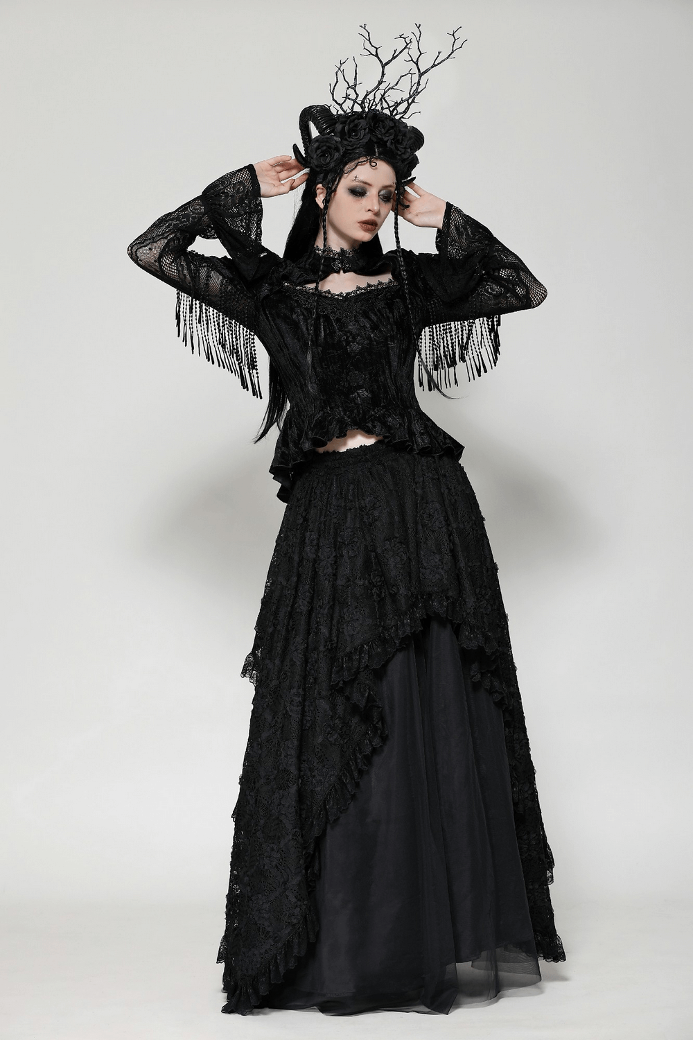 Elegant model in black Victorian-inspired Gothic outfit with lace and flared sleeves, showcasing a dramatic look.