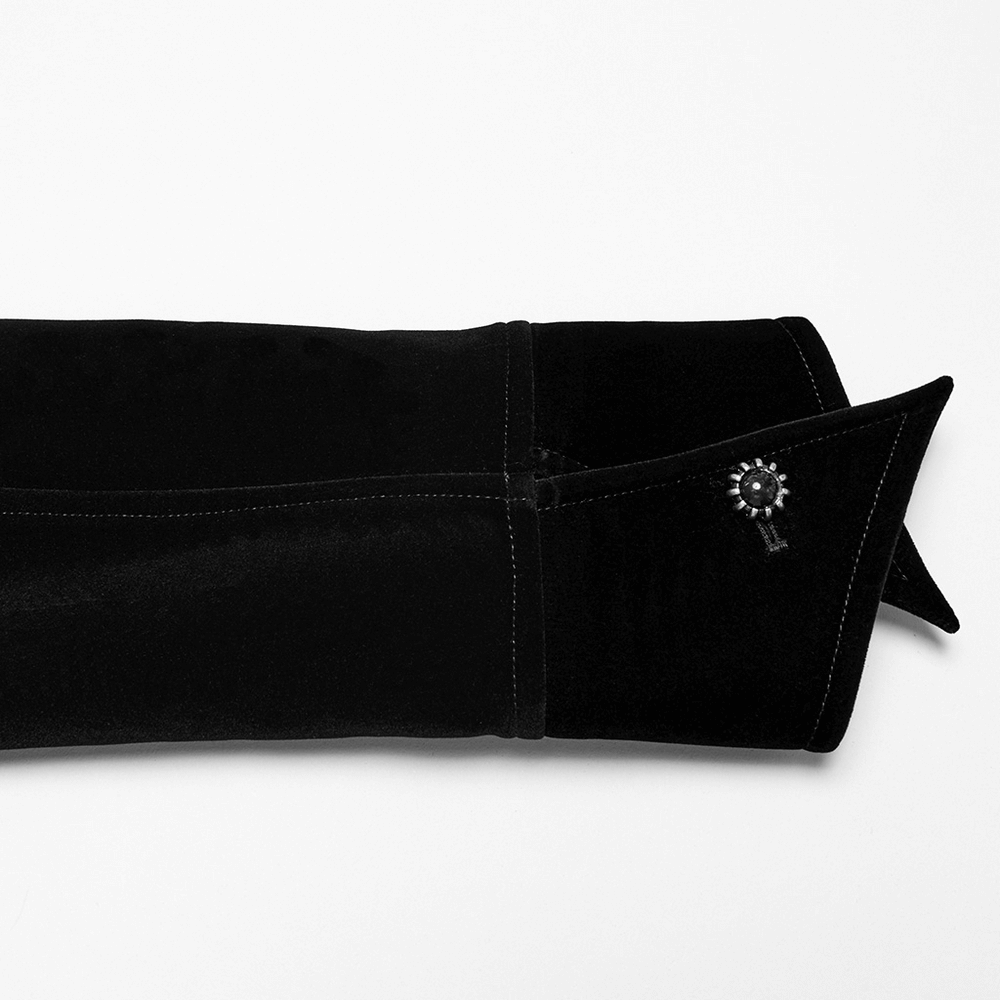 Close-up of Gothic velvet bat hem jacket cuff featuring gemstone buckle and sleek black fabric.