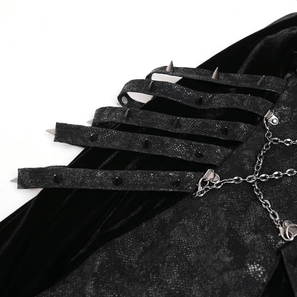 Close-up of gothic velvet dress featuring spiked faux leather straps and layered chain details, perfect for alternative fashion.