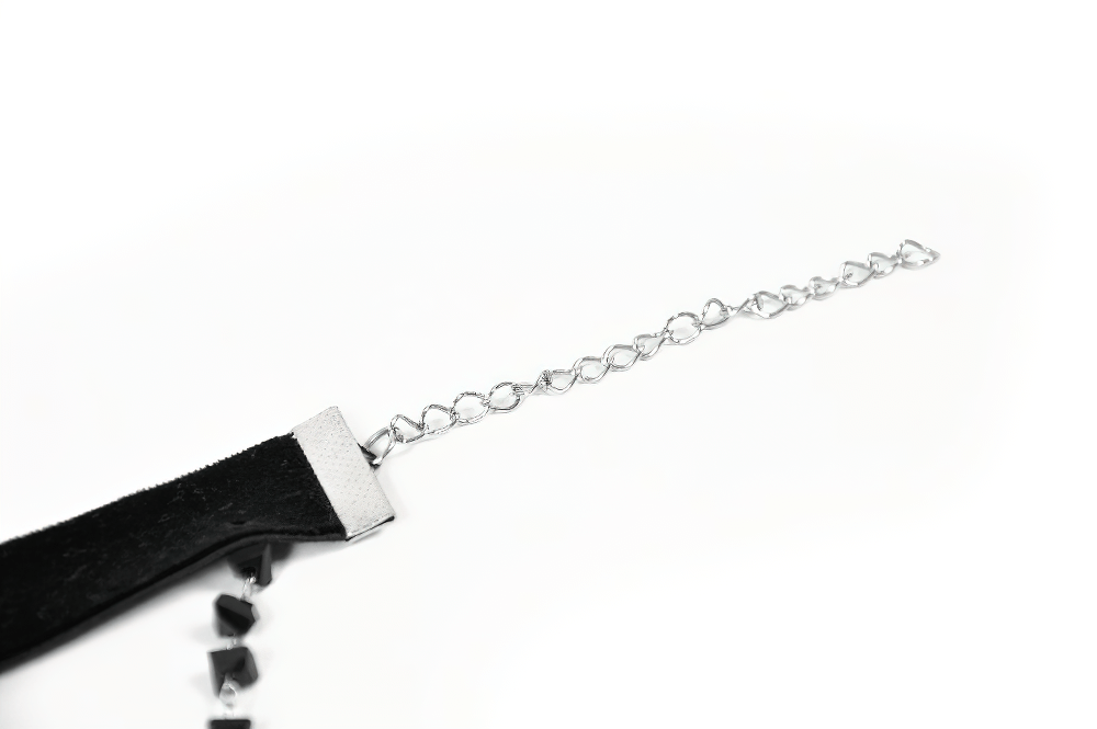 Close-up of a gothic velvet choker necklace with silver chain closure and black beads, perfect for elegant alternative fashion.