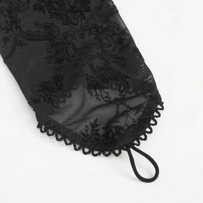 Close-up of a gothic velvet sleeve with intricate floral lace detailing and a delicate hem.
