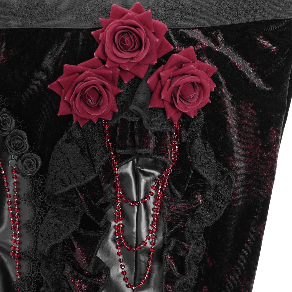 Close-up of gothic velvet flare pants featuring dramatic rose appliqués and cascading bead accents.