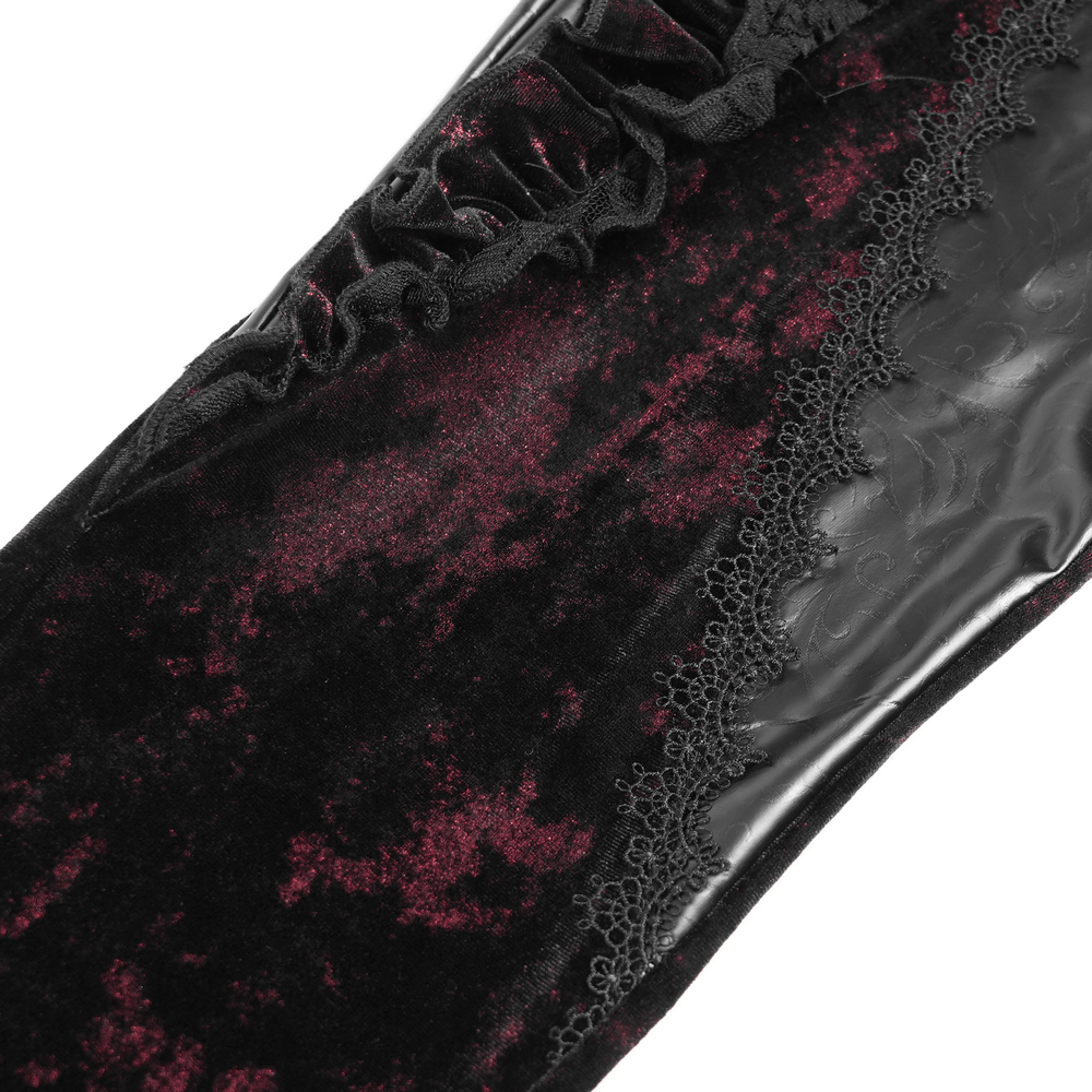 Close-up of gothic velvet flare pants showcasing rose appliqués and leather detailing with ornate ruffles.