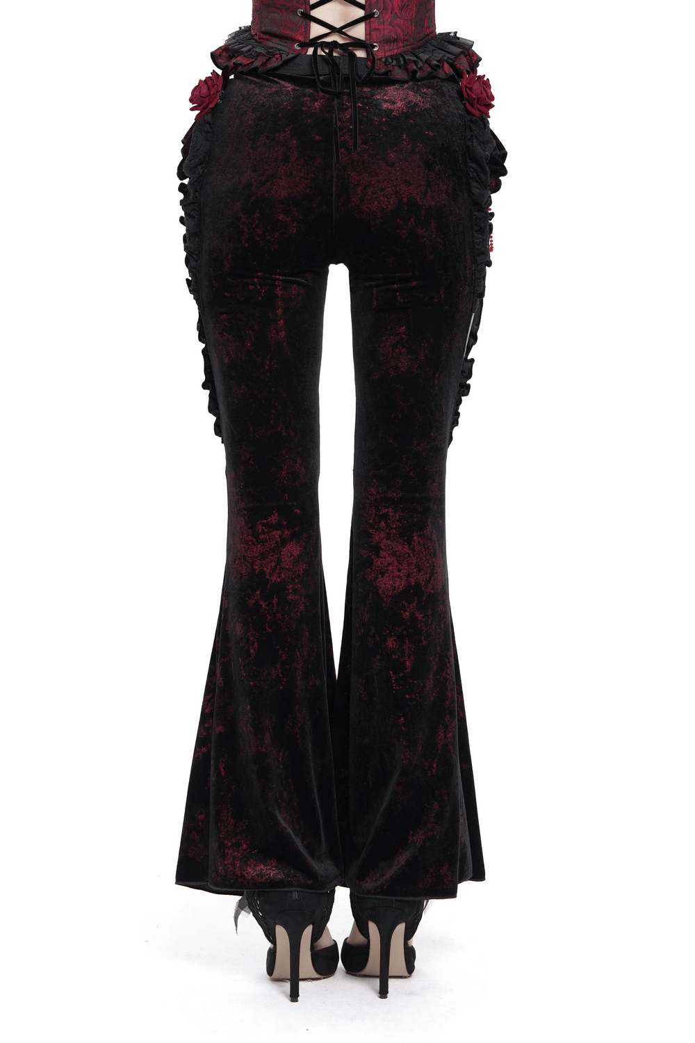 Gothic velvet flare pants with rose appliqués and leather details, showcasing a dramatic silhouette from the back.