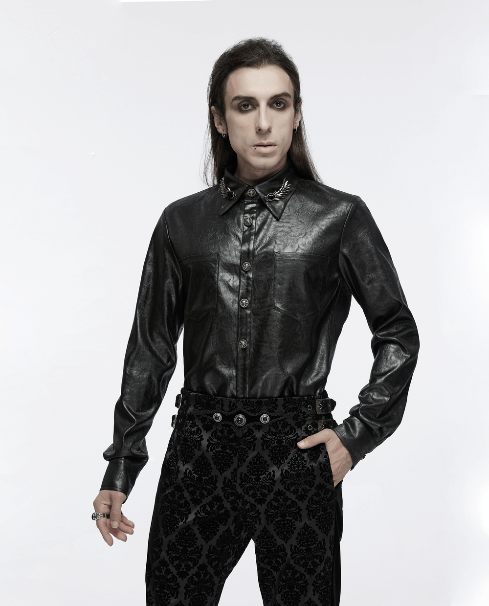 Gothic model showcasing stylish black velvet suit pants with gemstone buckles and a sleek leather shirt.