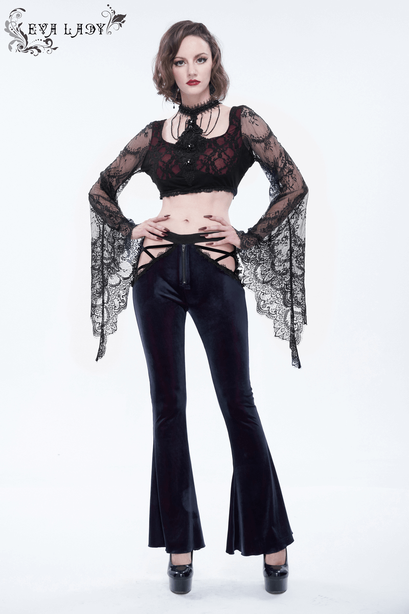 Stylish goth woman wearing black velvet flared trousers and lace top, showcasing elegant gothic fashion.
