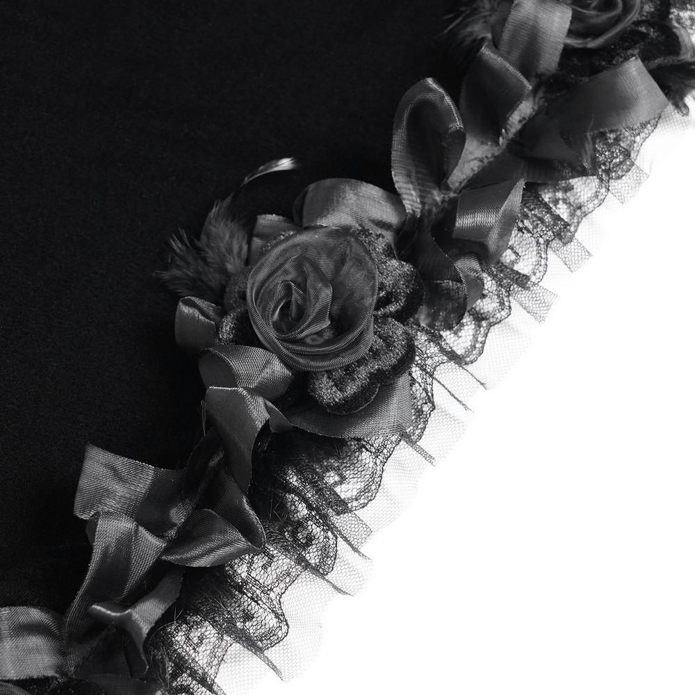 Close-up of black velvet cape showing floral rose detailing and fringed lace trim for gothic elegance.