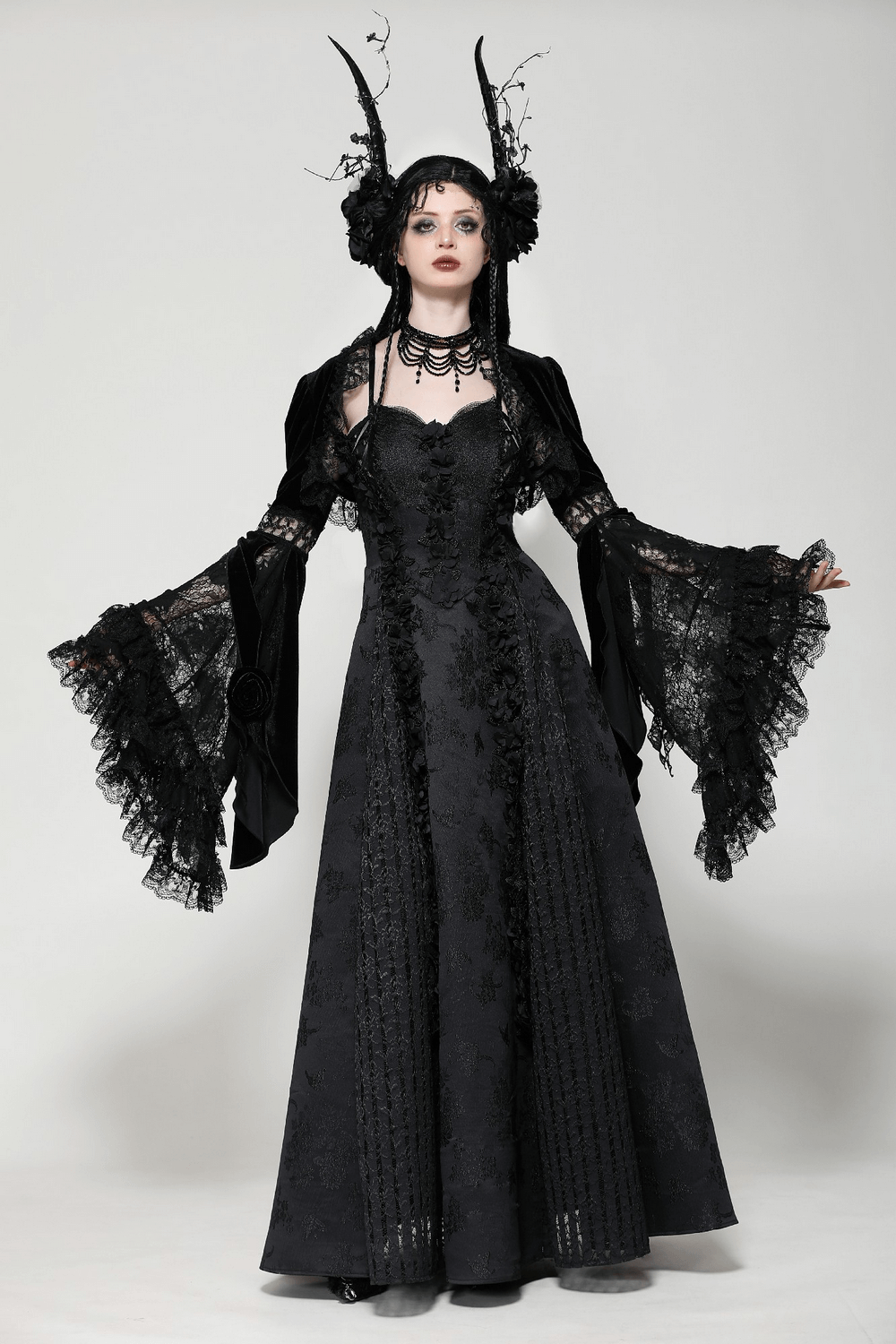 Elegant model wearing a Gothic velvet lace bolero with flared sleeves and a long black gown, showcasing dark romance.
