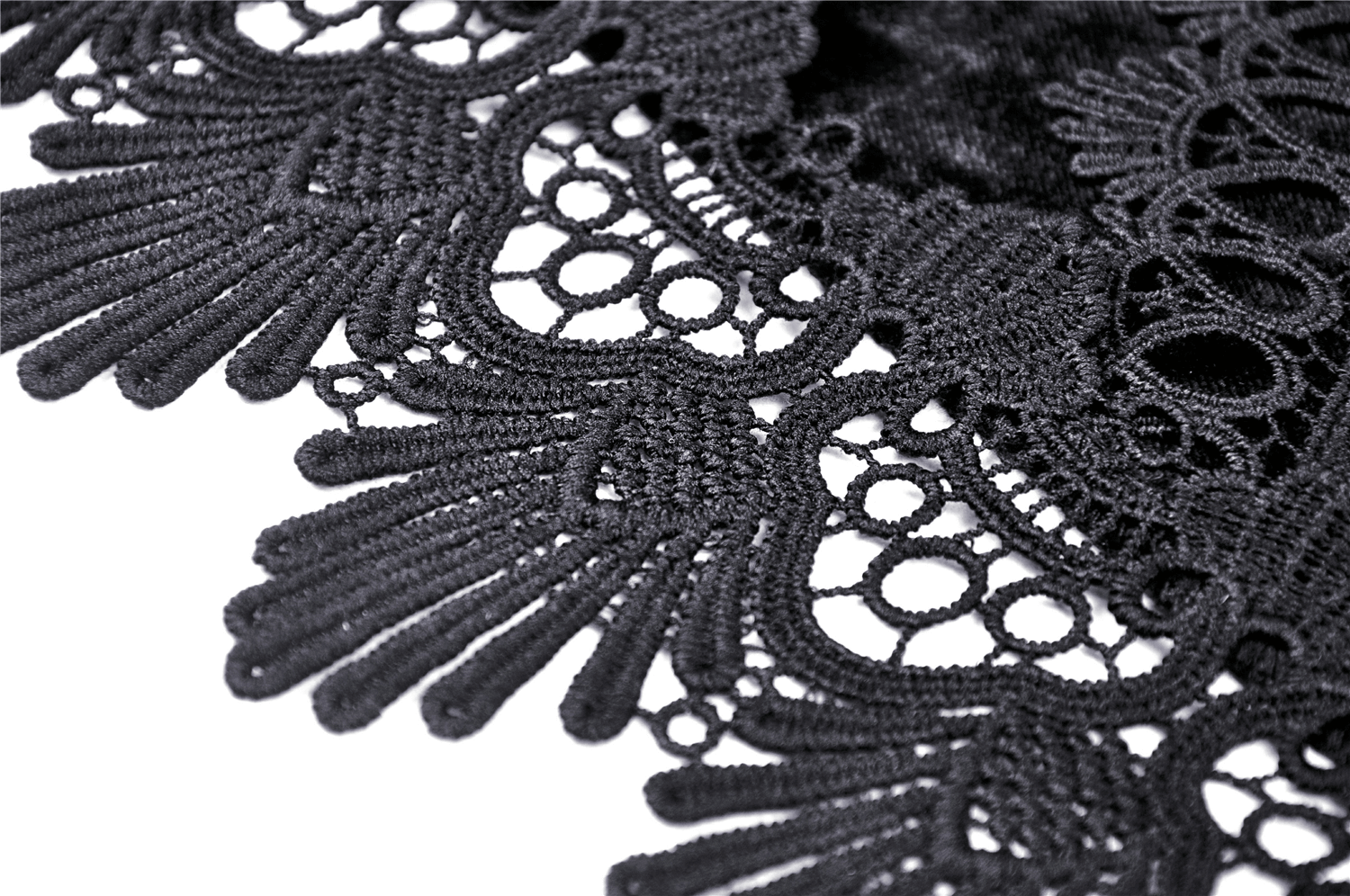 Close-up of intricate black lace trim showcasing delicate patterns and gothic design elements.