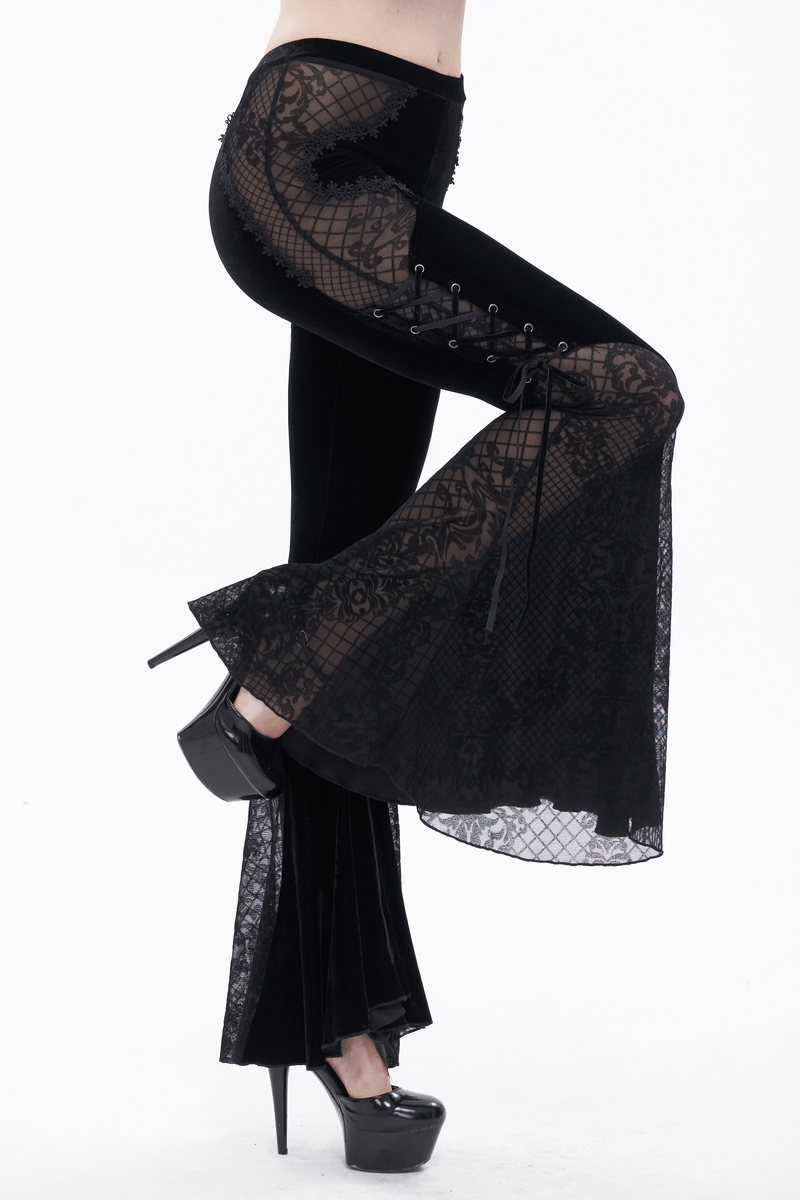 Woman wearing black velvet flared trousers with lace applique and side lacing, showcasing a gothic style.
