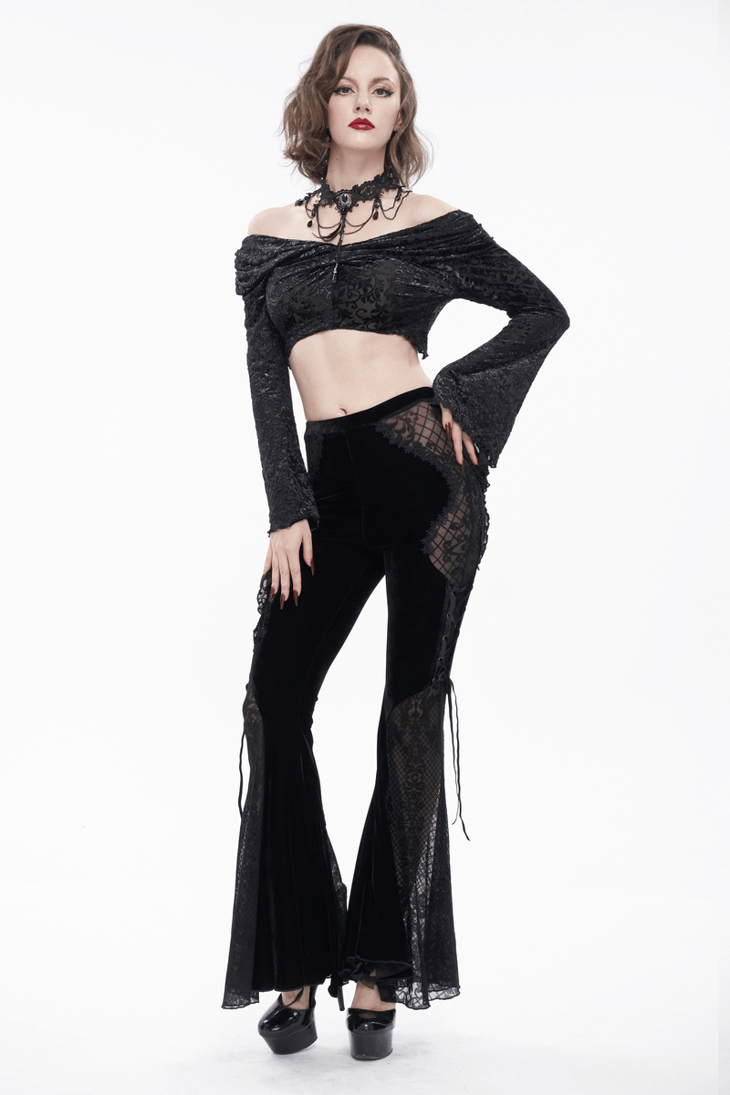 Model showcases elegant gothic black velvet flared trousers with lace-up sides and a chic off-shoulder top.