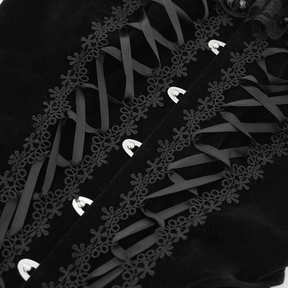 Close-up of gothic lace-up detailing on black velvet dress, featuring intricate lace accents and elegant corset style.