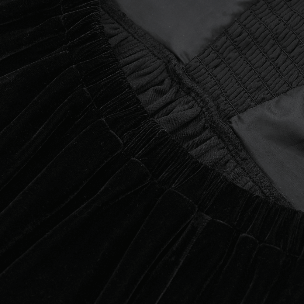 Close-up of black velvet fabric showing detailed lace-up and elastic features of a gothic maxi dress.