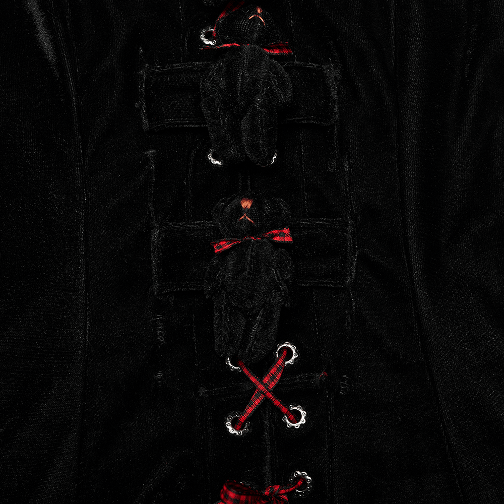 Close-up of black velvet dress detailing with playful 3D bear accents and red plaid webbing.