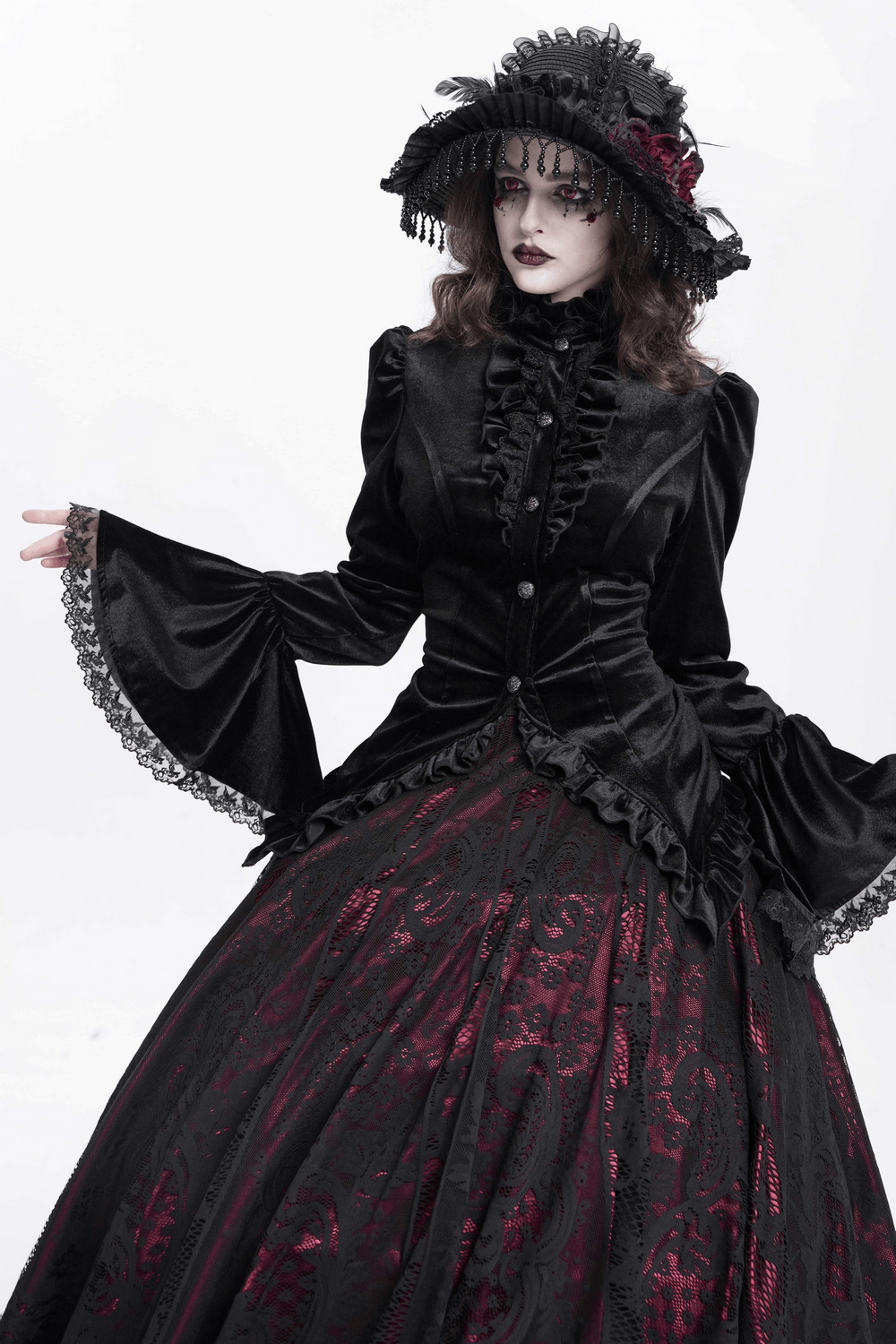 Gothic Victorian black velvet blouse with lace details and a dramatic ruffled collar, styled with a long dark skirt.