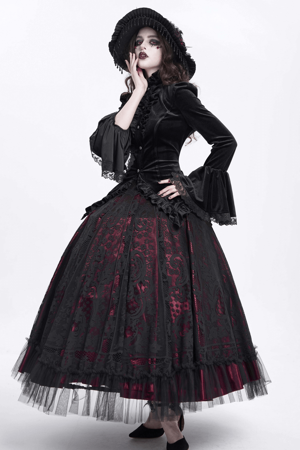 Gothic Victorian woman in black velvet blouse and dramatic skirt, showcasing elegant ruffles and lace details.