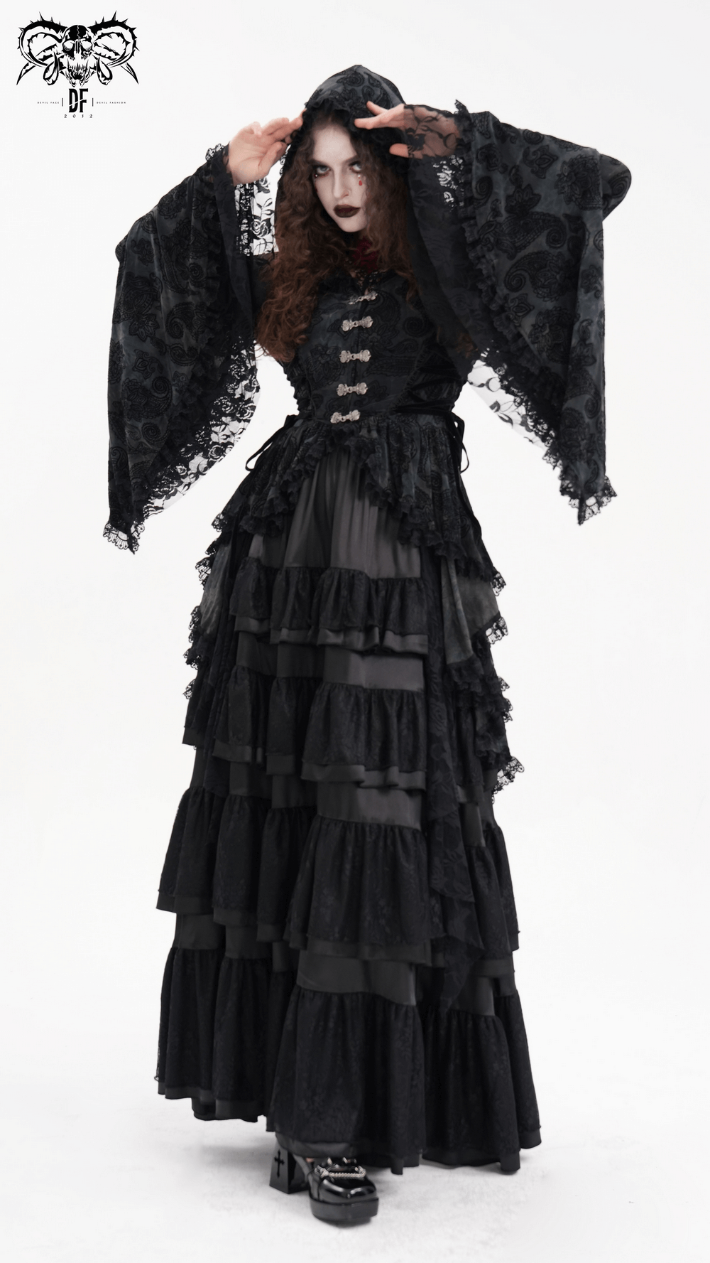 Elegant Gothic Victorian model in hooded lace cape and layered black dress, showcasing dark elegance and intricate details.