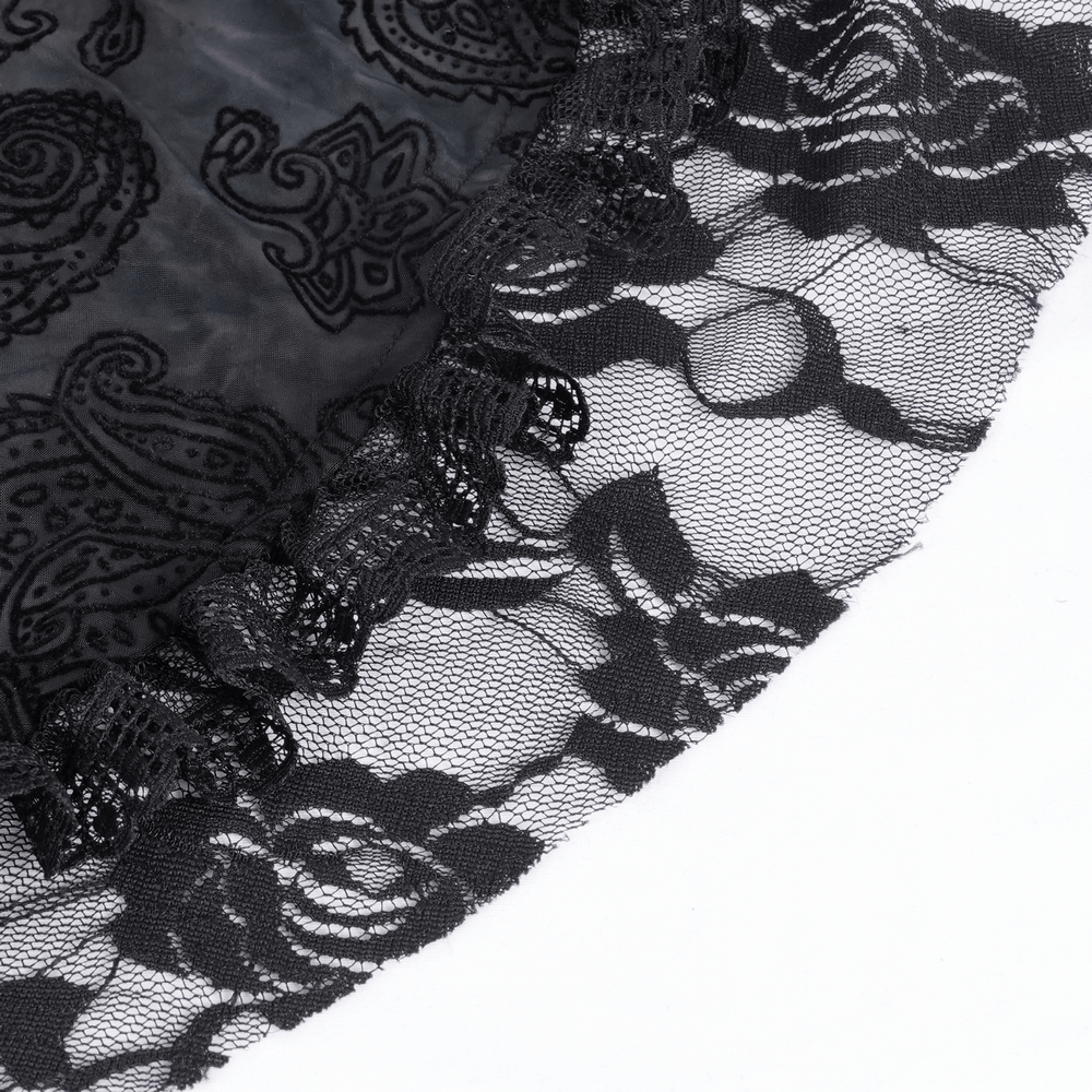 Close-up of intricate black lace detailing on a Gothic Victorian hooded cape, featuring ornate floral patterns.