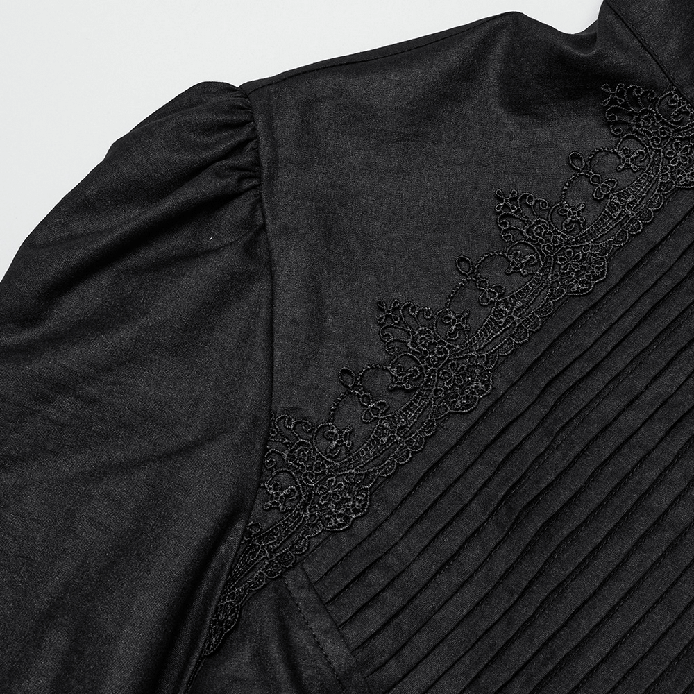 Gothic Victorian shirt detail featuring ruffled sleeves, pleated front, and elegant lace trim on textured black fabric.