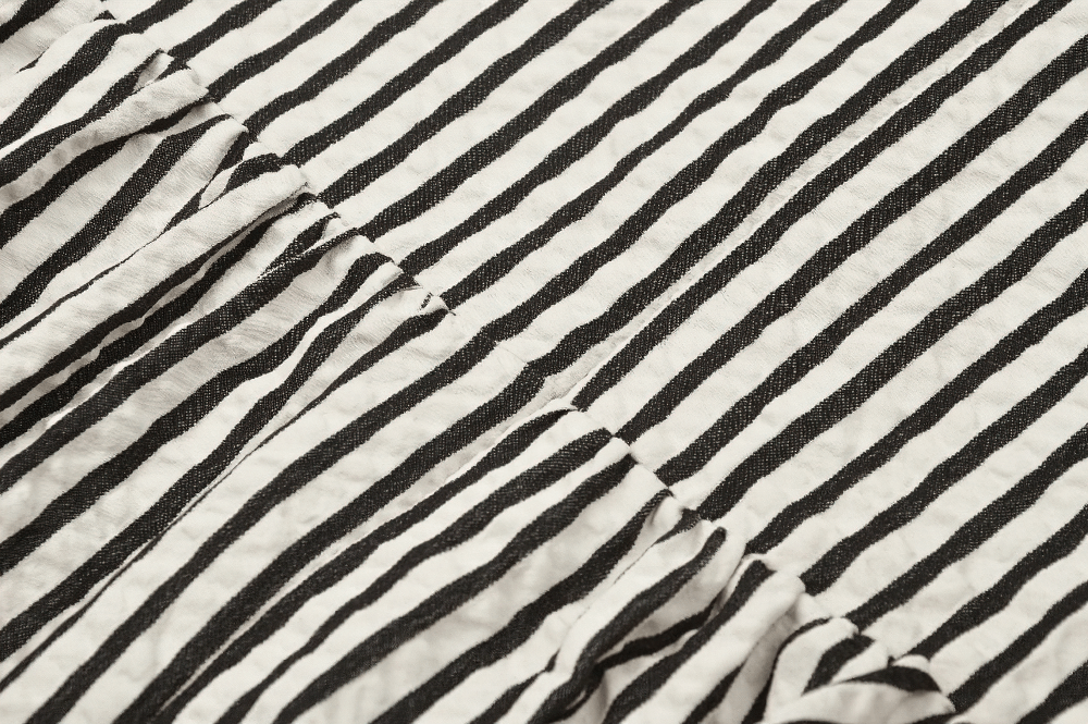 Close-up of Gothic Victorian striped fabric in black and white, perfect for a darkly elegant dress.