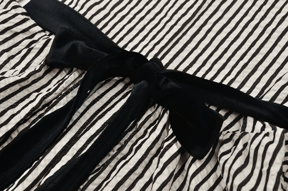 Close-up of a Gothic Victorian striped dress with a black velvet belt and lace details, perfect for channeling inner goth princess.