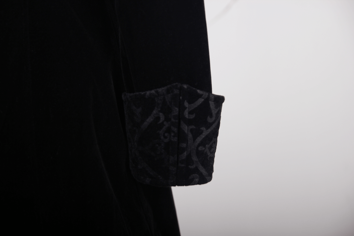 Close-up of the elegant black trench coat cuff featuring stylish steampunk embroidery details.