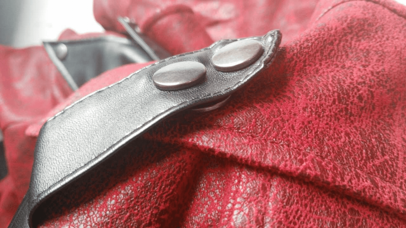 Close-up of the button and collar detail on a gothic vintage long red men's coat, showcasing quality PU leather craftsmanship.