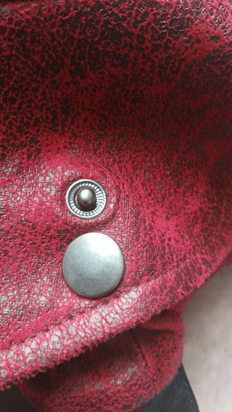 Close-up of the metallic button details on a gothic vintage long red men's coat.
