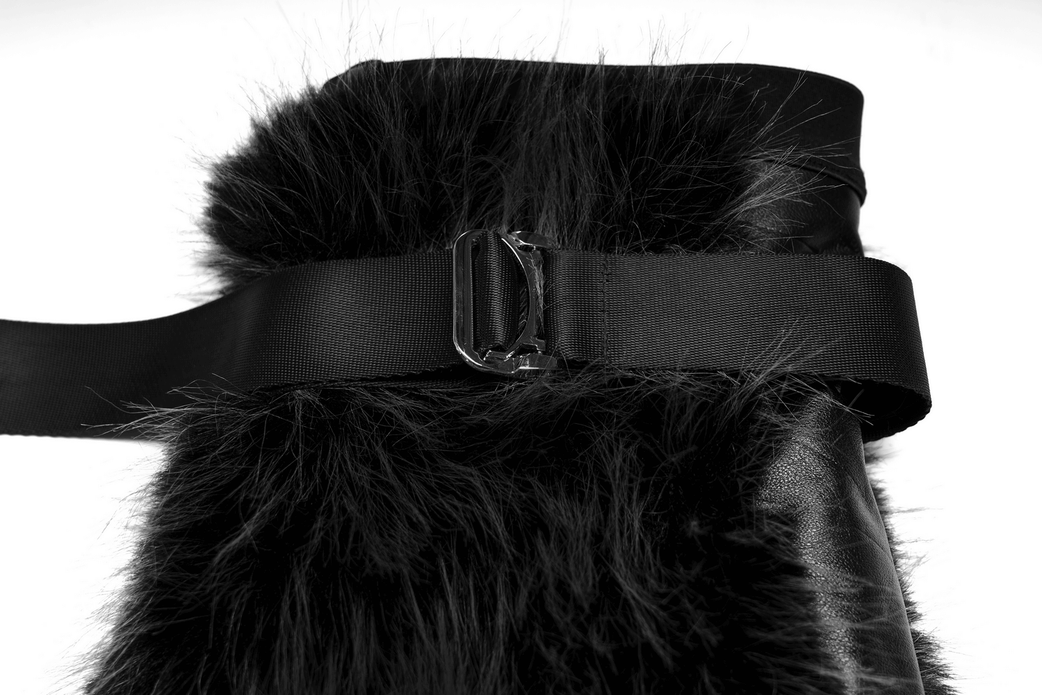 Close-up of gothic black faux fur leg warmers with detachable loops and adjustable buckle for a custom fit.