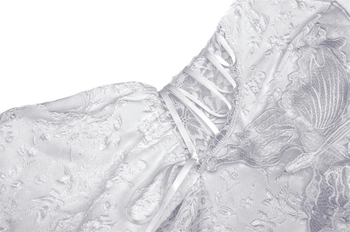 Close-up of the corset bodice of a white Gothic dress with delicate butterfly embroidery.
