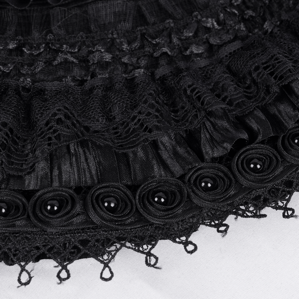 Close-up of intricate black lace, ruffles, and decorative rosettes on a gothic wide-brim hat.