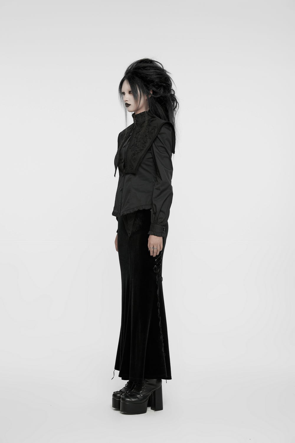 Gothic wide shoulder lace-up shirt with ruffle details, styled with a long black skirt and platform boots.