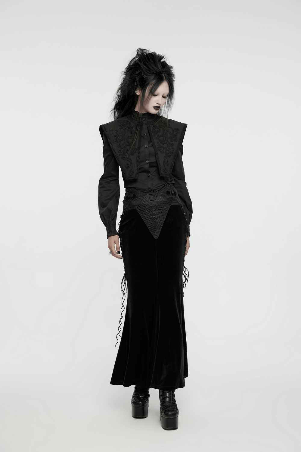 Gothic wide shoulder lace-up shirt with ruffle details, paired with sleek black velvet skirt, showcasing a retro-inspired look.