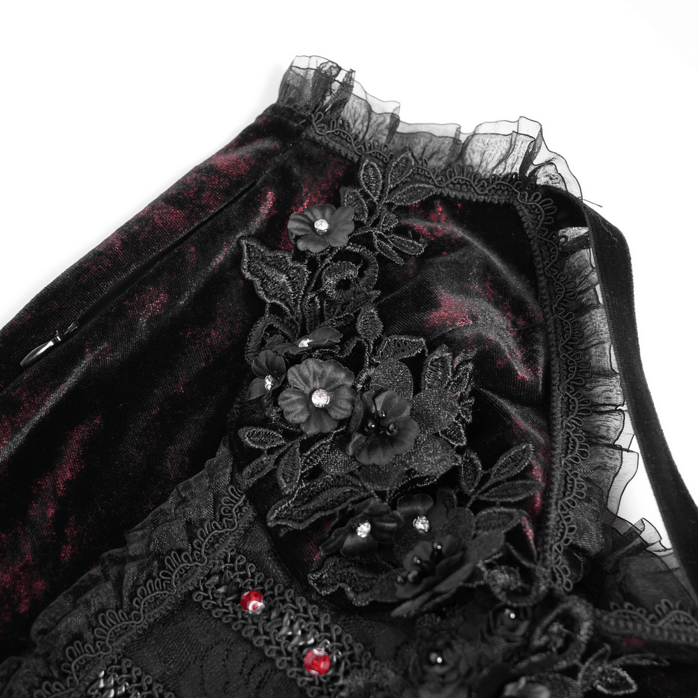 Close-up of black velvet dress featuring intricate floral lace and fringe details, enhancing gothic elegance.