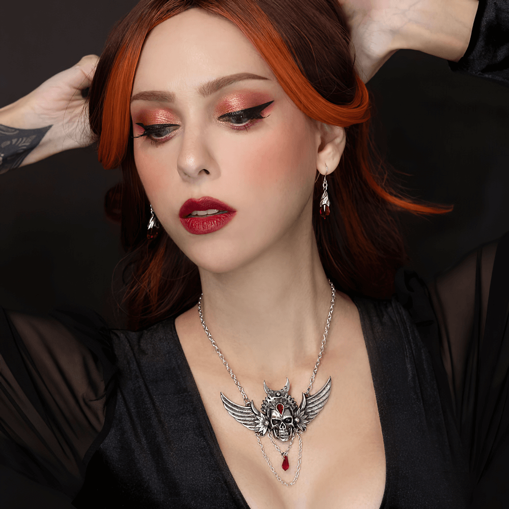 Gothic Winged Skull Necklace with Red Crystal Drop worn by model, showcasing a dramatic gothic style.