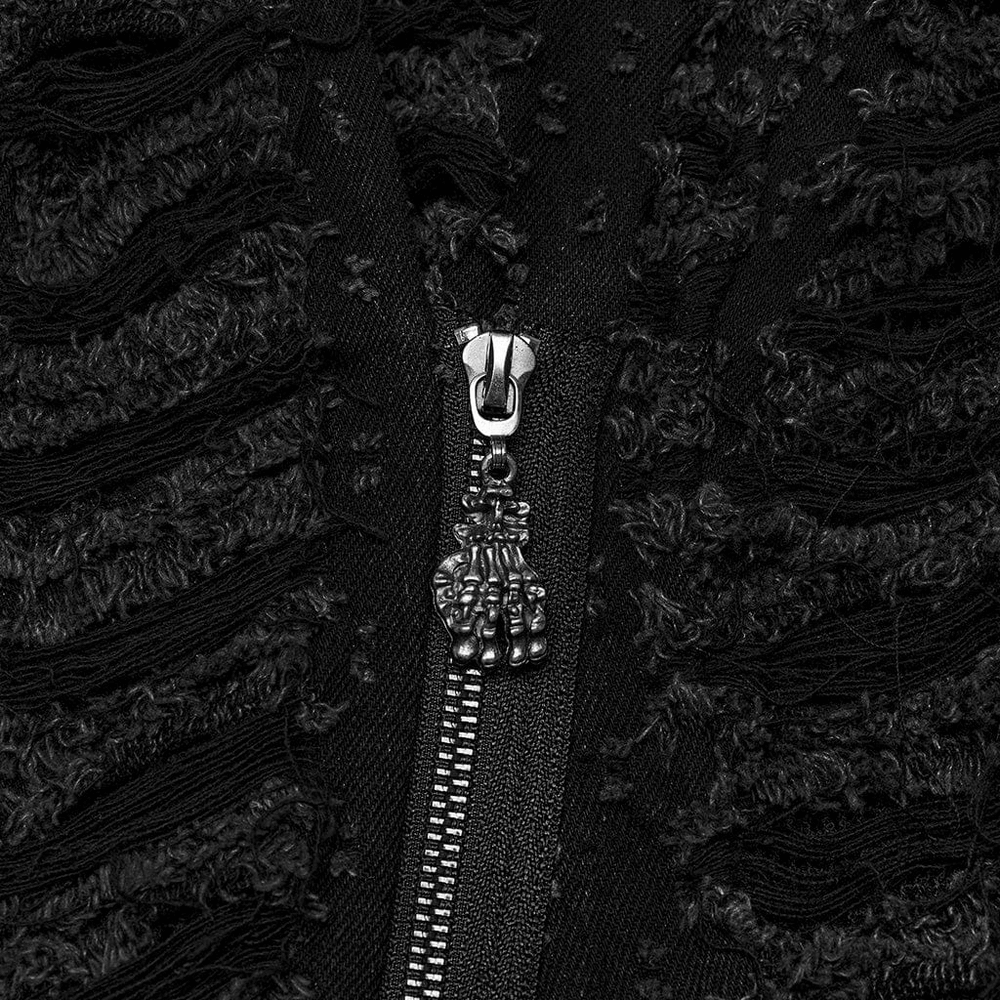 Close-up of the unique zipper detail featuring a skull charm on a black Gothic cape with textured fabric.