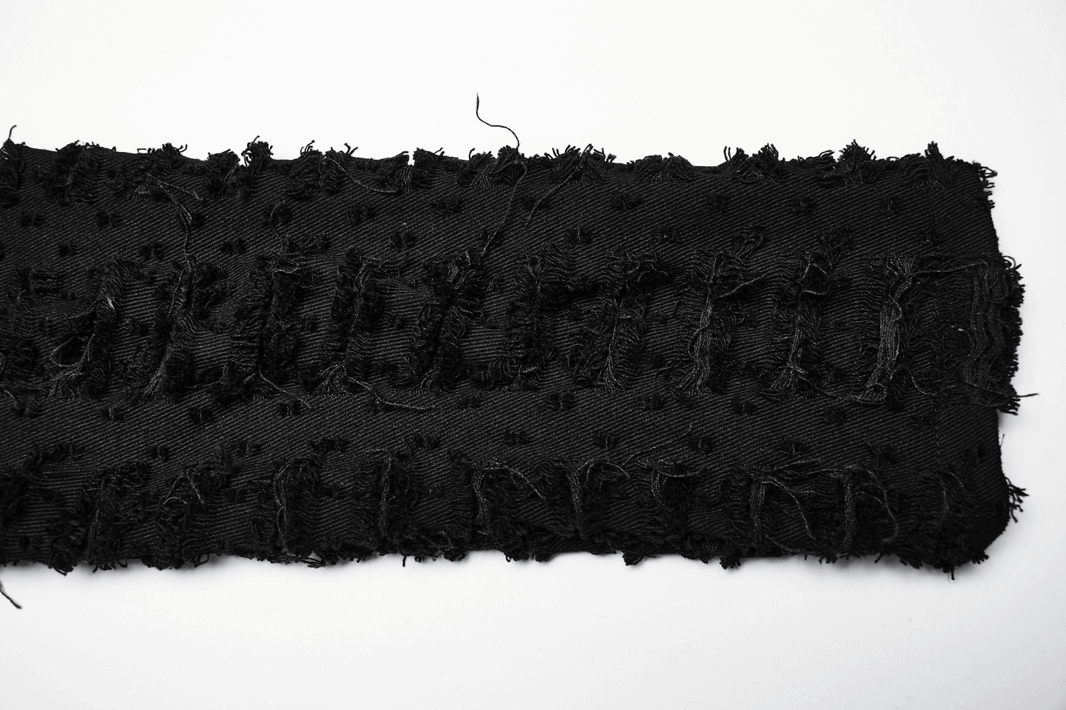 Distressed black fabric showcasing textured patches and frayed edges, ideal for Gothic fashion designs.