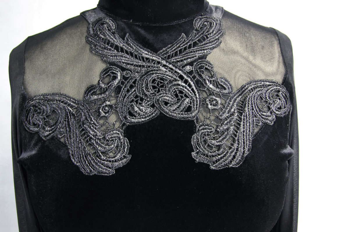 Close-up of intricate black velvet dress detailing with transparent fabric and elegant embroidery design.