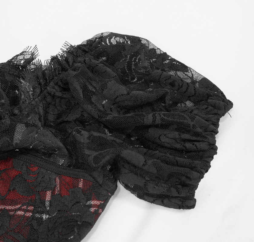 Close-up of the lace fabric of a gothic women's black and red plaid crop top showcasing floral patterns.