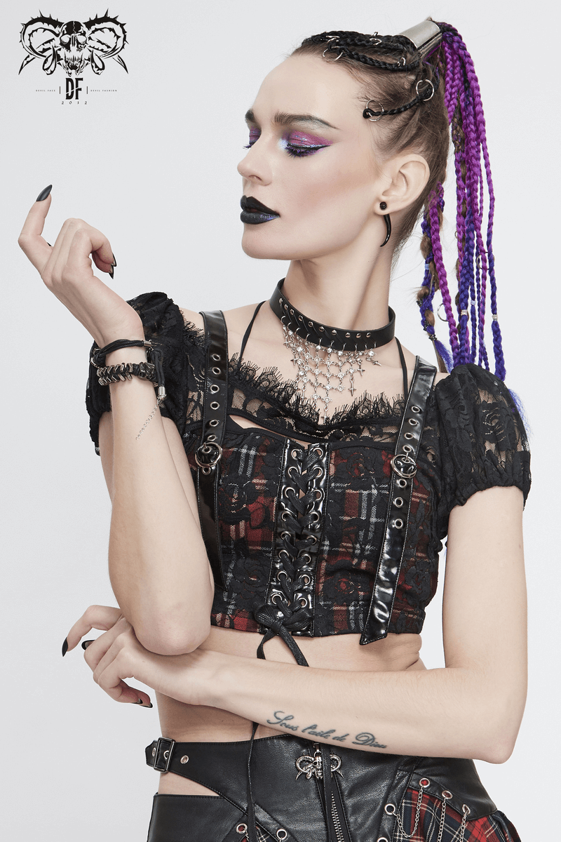 Trendy goth woman in a black and red plaid crop top with lace, showcasing a bold look and stylish accessories.