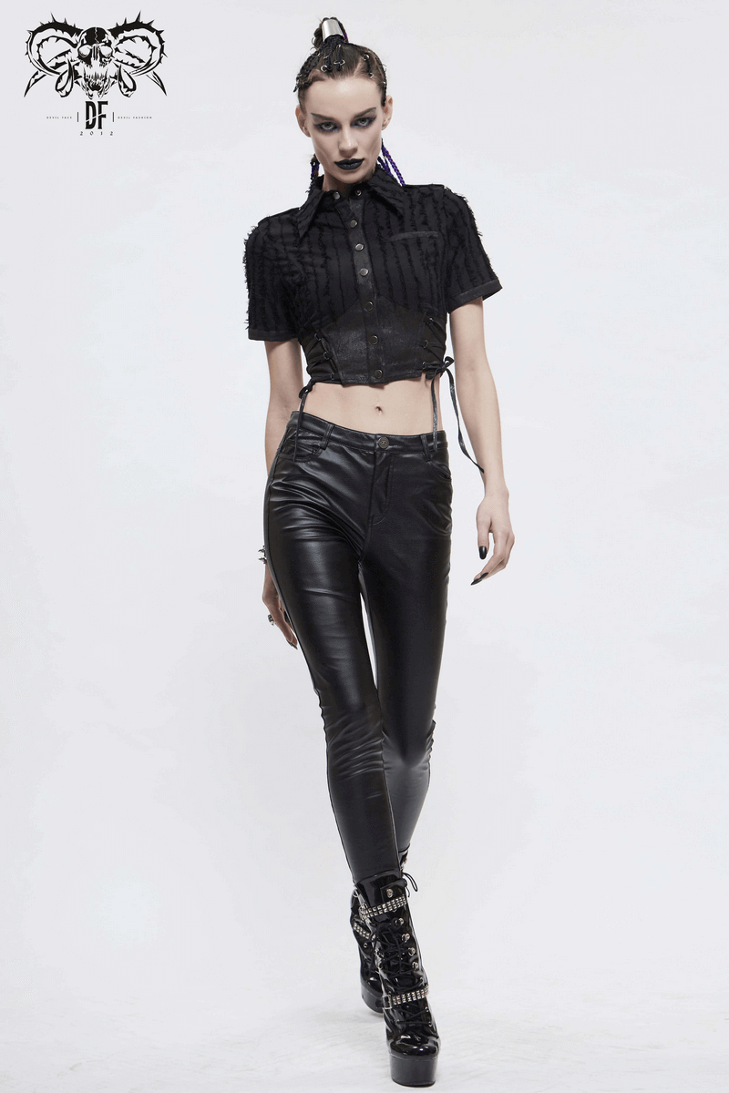 Trendy gothic women's black short sleeve blouse with button details, paired with sleek black pants and stylish ankle boots.