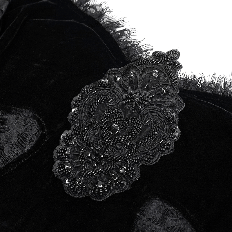 Close-up of black velvet top's intricate lace appliqué with beads, showcasing gothic vintage style elegance.