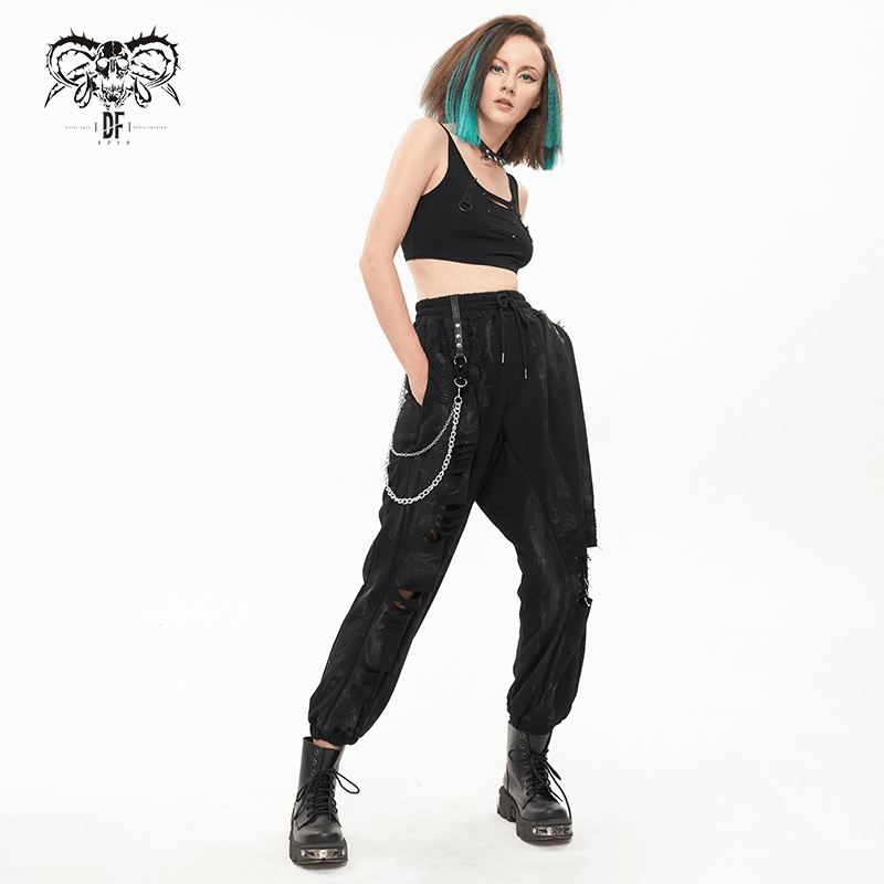 Stylish gothic woman in black elastic waist cargo pants with chains, rivets, and loops, posing confidently.